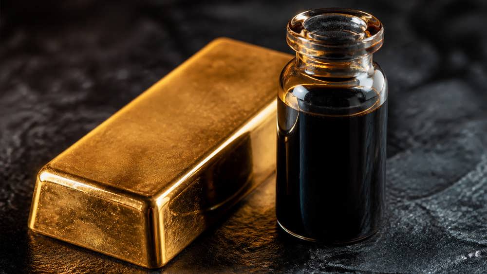 یک شمش طلای صیقلی در کنار ظرف شیشه ای ظریفی از نفت خام با نورپردازی دراماتیک و پس زمینه تاریک.