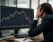 مرد تاجر مضطرب در حال تماشای ریزش بازار سهام روی مانیتور